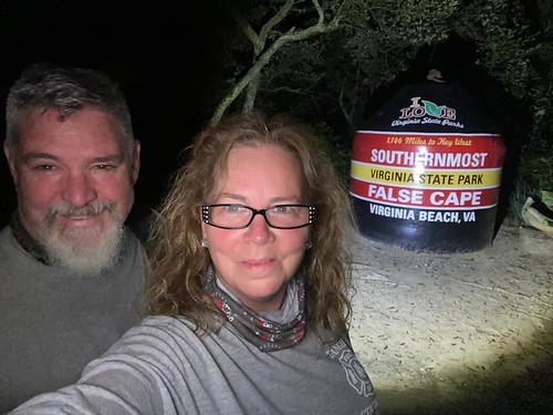 RJ and Debra taking a selfie at night in front of the "Southern Most Point of Virginia" trail marker